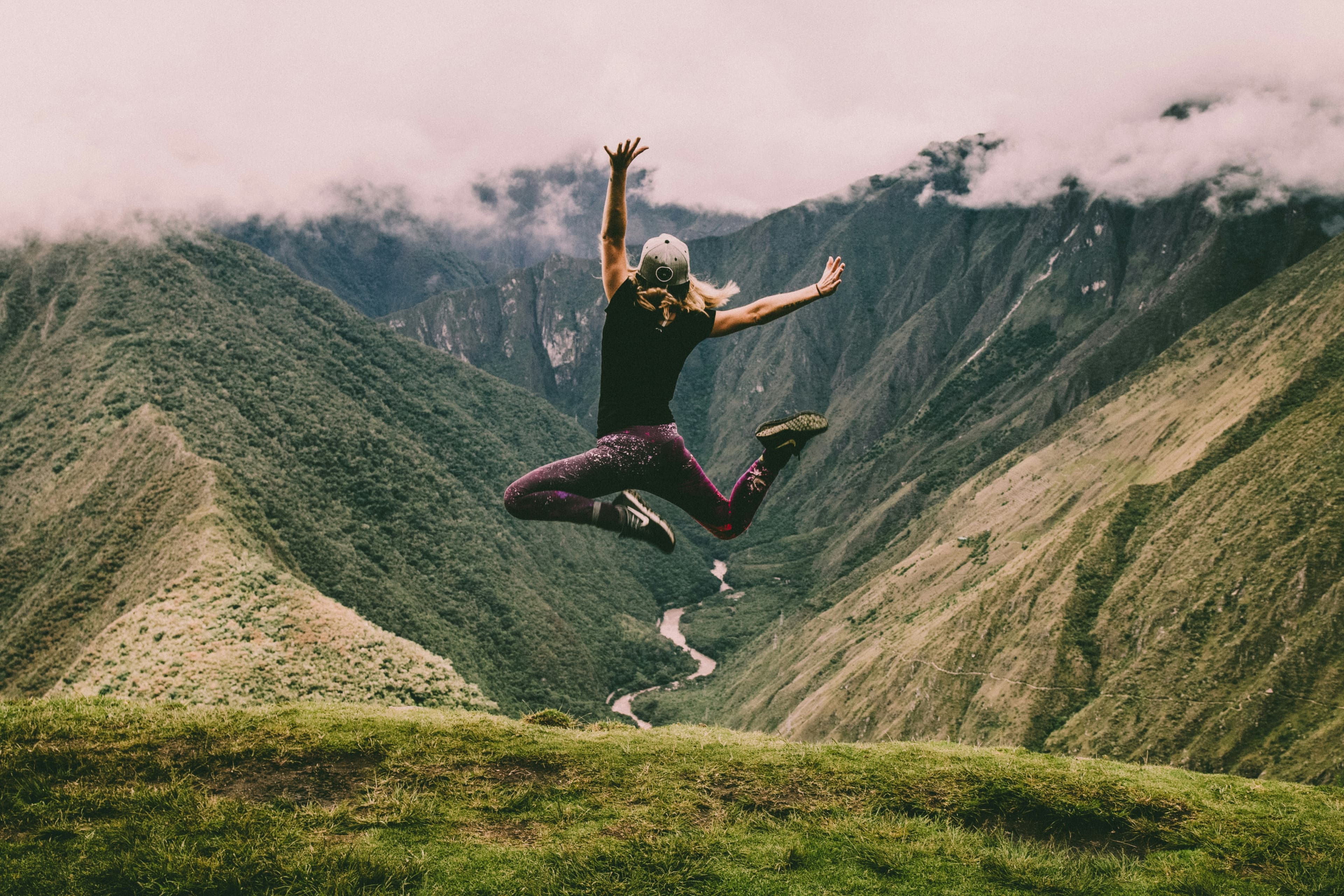 Woman jumping with mountain view